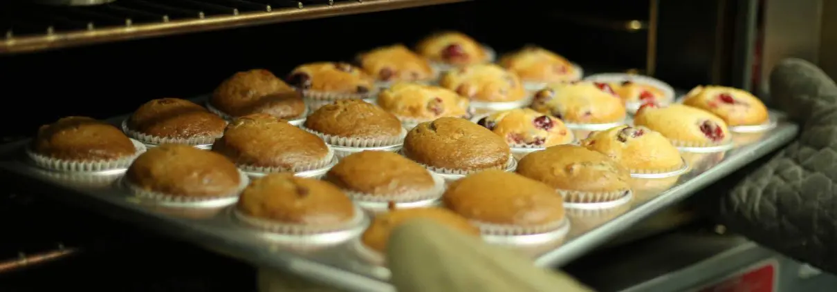 Bakery cakes on a baking tray coming out of an oven
