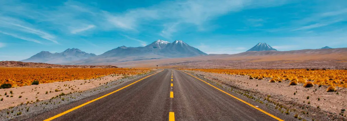 Road passing through desert towards mountains