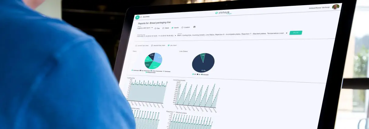 Someone at a desktop screen, using the innius production logistics data report to analyse machine production per production order